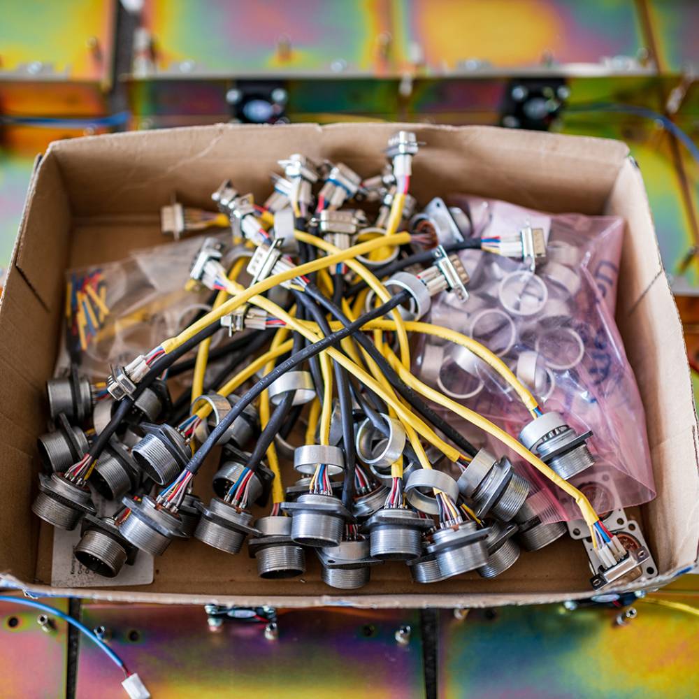 Connecting cords with metal plugs for contemporary TFT monitors in cardboard box in production plant workshop extreme close view